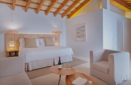 Interior de la habitación Torralbenc Cottage con cama doble y vigas de madera