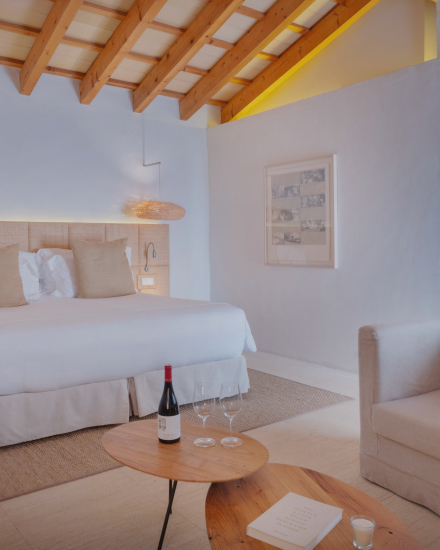 Interior de la habitación Torralbenc Cottage con cama doble y vigas de madera