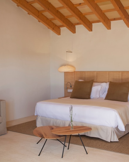 Dormitorio de la habitación Torralbenc Cottage con techo de vigas de madera y diseño mediterráneo