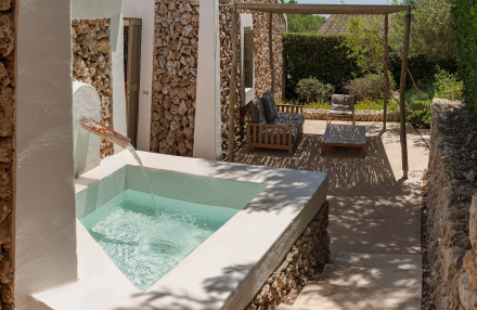 Fuente exterior privada en la terraza de la Garden Cottage, espacio de descanso en Torralbenc Menorca