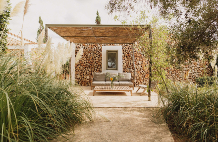 Vista frontal de la Garden Cottage con terraza privada y entorno natural en Menorca