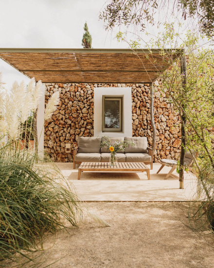 Vista frontal de la Garden Cottage con terraza privada y entorno natural en Menorca
