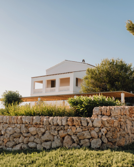 Edificio blanco elevado con porche y muro de piedra de la habitación Gran Vista Mar