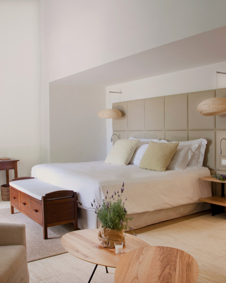 Dormitorio de la Suite Superior en Torralbenc con cama doble, textiles naturales y decoración mediterránea