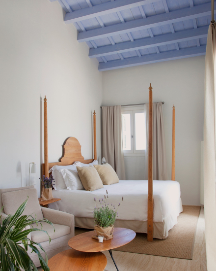 Interior de la habitación Superior Suite con cama con dosel y techo con vigas de madera