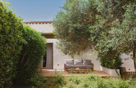 Terraza privada de la Suite Superior en Torralbenc con sofá exterior y entorno ajardinado