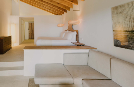 Interior de la habitación Vista Mar en Torralbenc, con cama amplia, zona de estar y luz natural