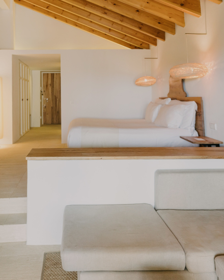 Interior de la habitación Vista Mar en Torralbenc, con cama amplia, zona de estar y luz natural