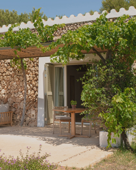 Terraza exterior de la habitación Vista Mar con mesa y sillas junto a la fachada