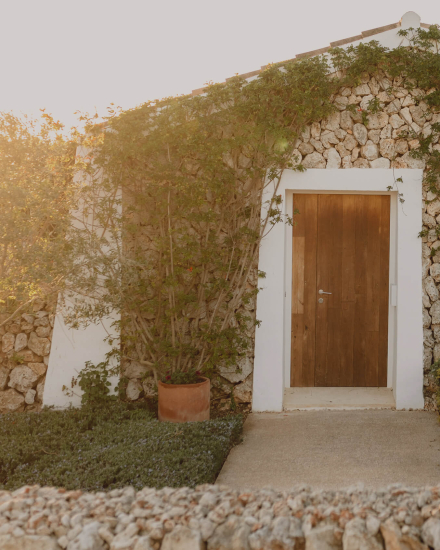 Fachada exterior de la habitación Torralbenc Cottage con muros de piedra tradicional en Menorca