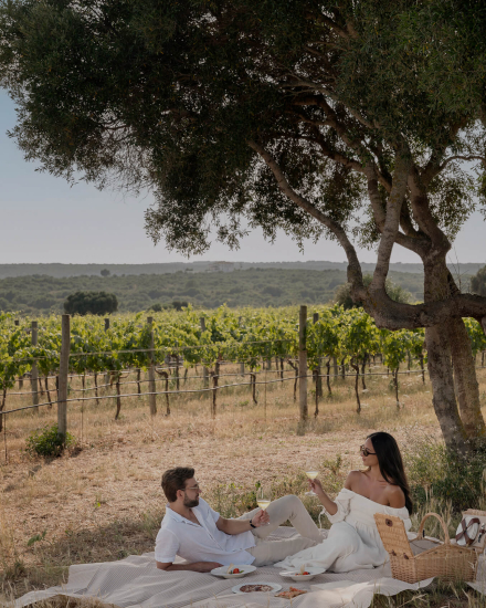 Pareja disfrutando de una experiencia de enoturismo en los viñedos de la bodega Torralbenc en Menorca
