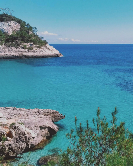 Aguas turquesas y acantilados de la costa de Menorca, escenario ideal para la experiencia de esquí acuático